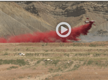 Plane spraying flame retardant on fire area
