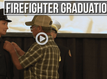 Father pinning badge on new firefighter in dress uniform 