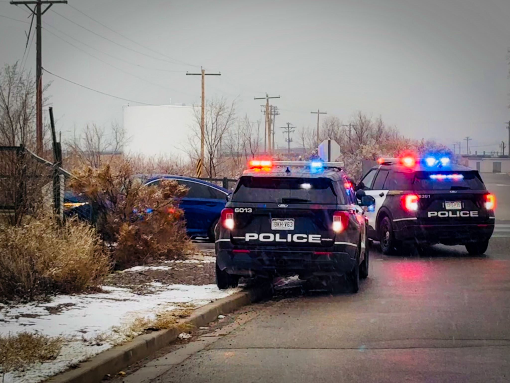 Two GJPD patrol cars on a roadway with crashed vehicle