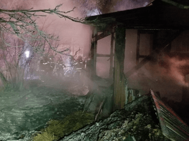 Home on fire, firefighters in background