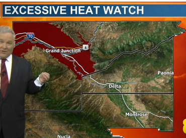 Weather man standing in front of screen while presenting the news