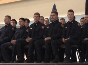 Fire academy graduates sitting on stage while waiting ceremony