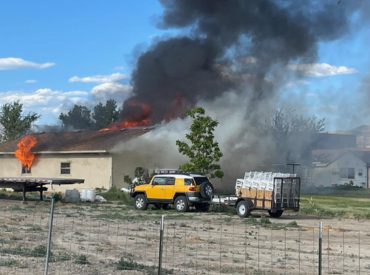 garage on fire with a vehicle nearby