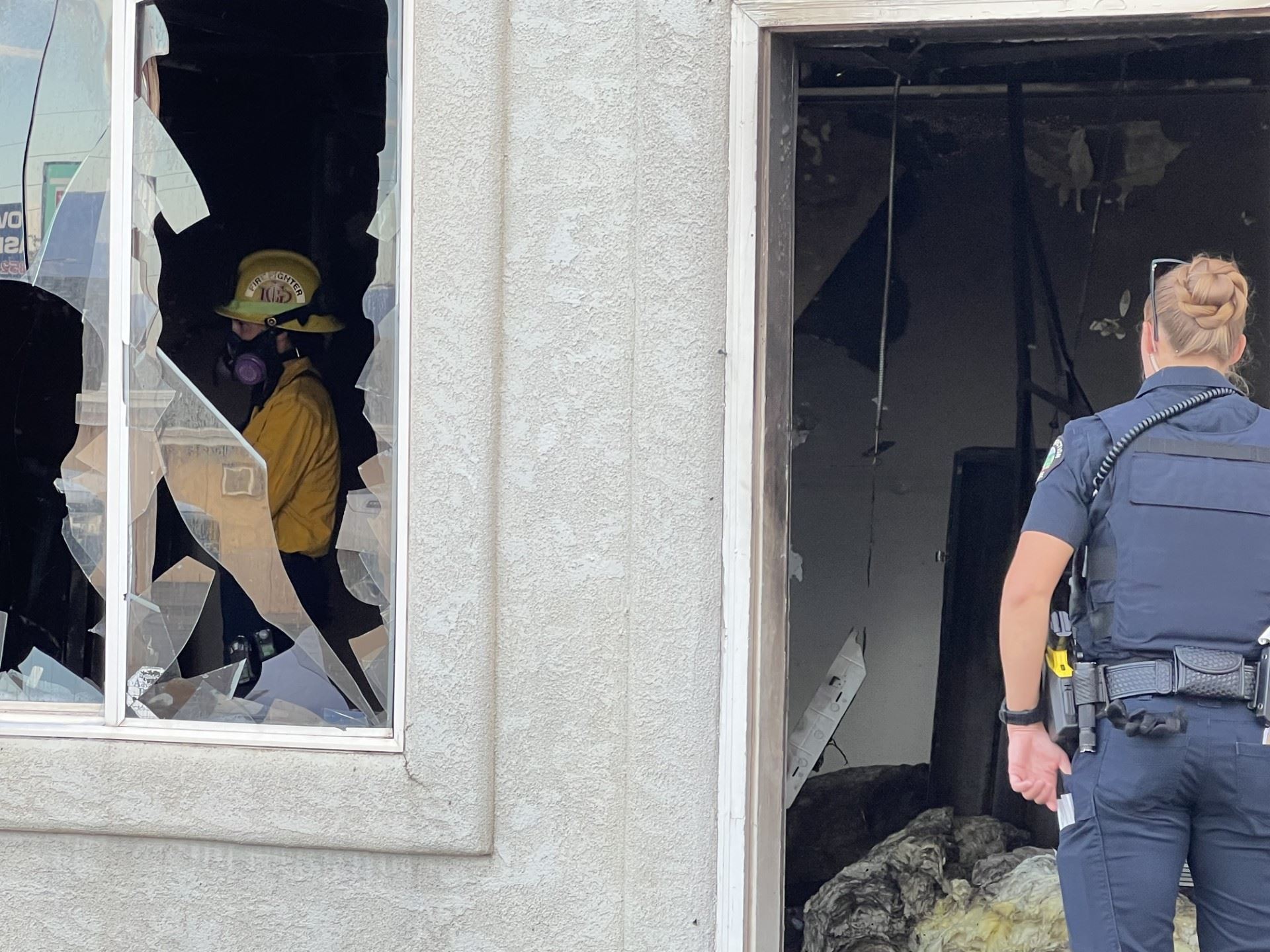 officer and fire investigator talking in doorway of fire incident